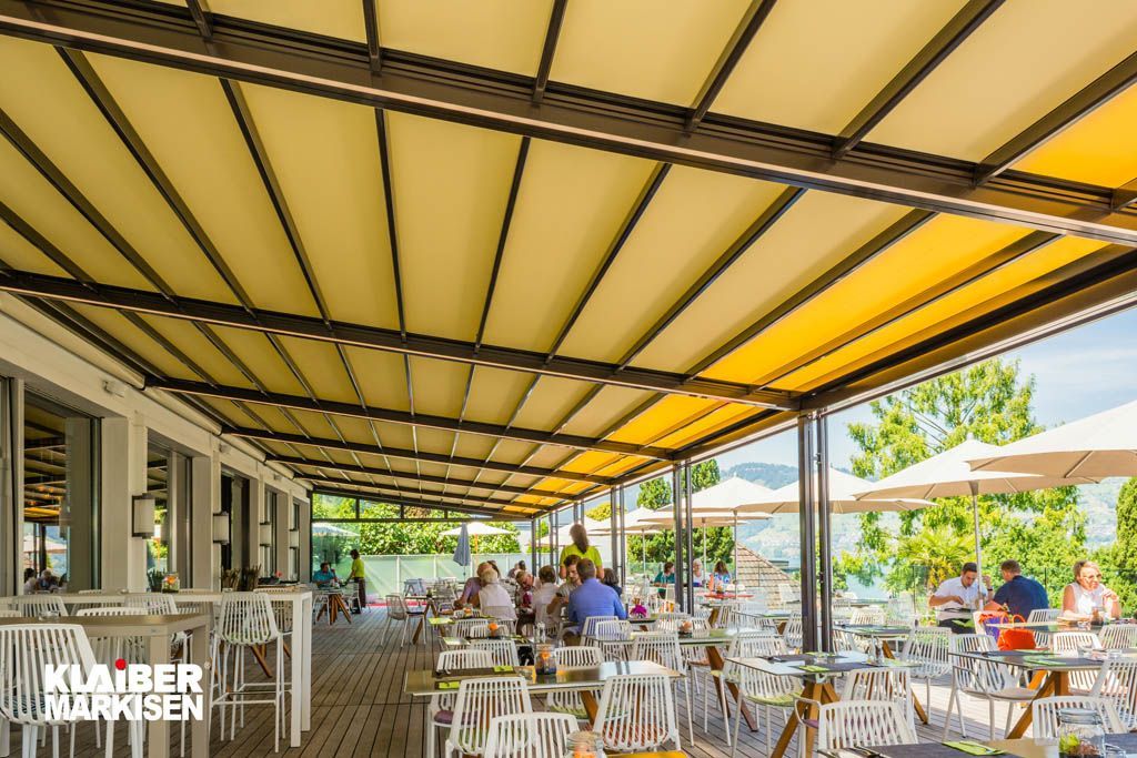 Ein Restaurant mit Tischen und Stühlen unter einem Baldachin.