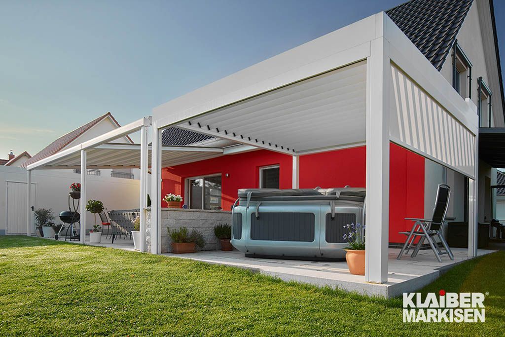 Ein Whirlpool steht unter einer Pergola im Hinterhof eines Hauses.