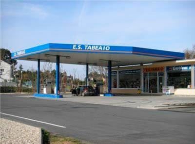 Gasolinera E.S. Tarlac con techo azul, surtidores y tienda de conveniencia bajo un cielo despejado