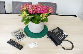 LTisch mit Blumen, Telefon und Taschenrechner, Dr. Volker Lührmann