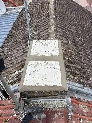 Une cheminée au sommet d'un toit avec une antenne parabolique attachée dessus.