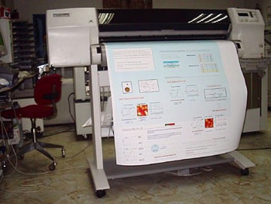 Impresora de gran formato que imprime un cartel con texto y gráficos; configuración interior.