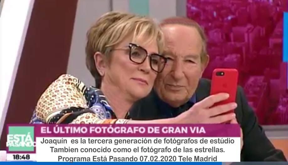 Dos personas tomándose un selfie en un estudio; texto en pantalla: 