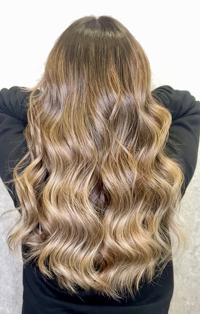 Una mujer pelirroja se está peinando en la peluquería.