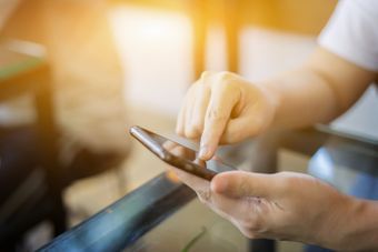 Mies näppäilee puhelinta