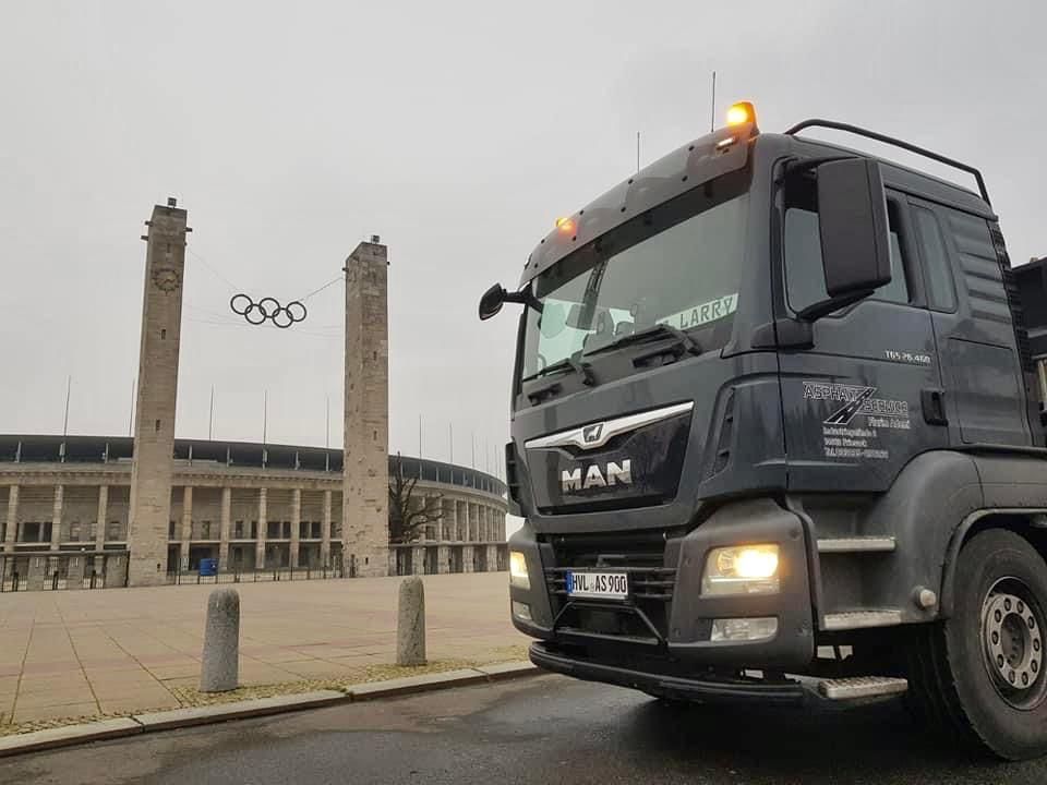 LKW vor einem Gebäude mit den olympischen Ringen