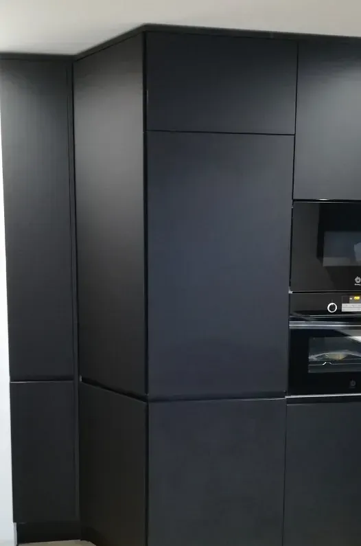 Muebles de cocina modernos en color negro mate con horno y microondas integrados.