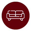 Un icono blanco de un sofá de dos plazas centrado sobre un fondo circular de color rojo oscuro.