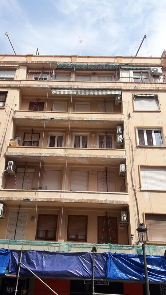 Un edificio con una lona azul en el costado.