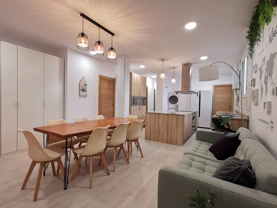 Una sala de estar con una mesa y sillas y un sofá.