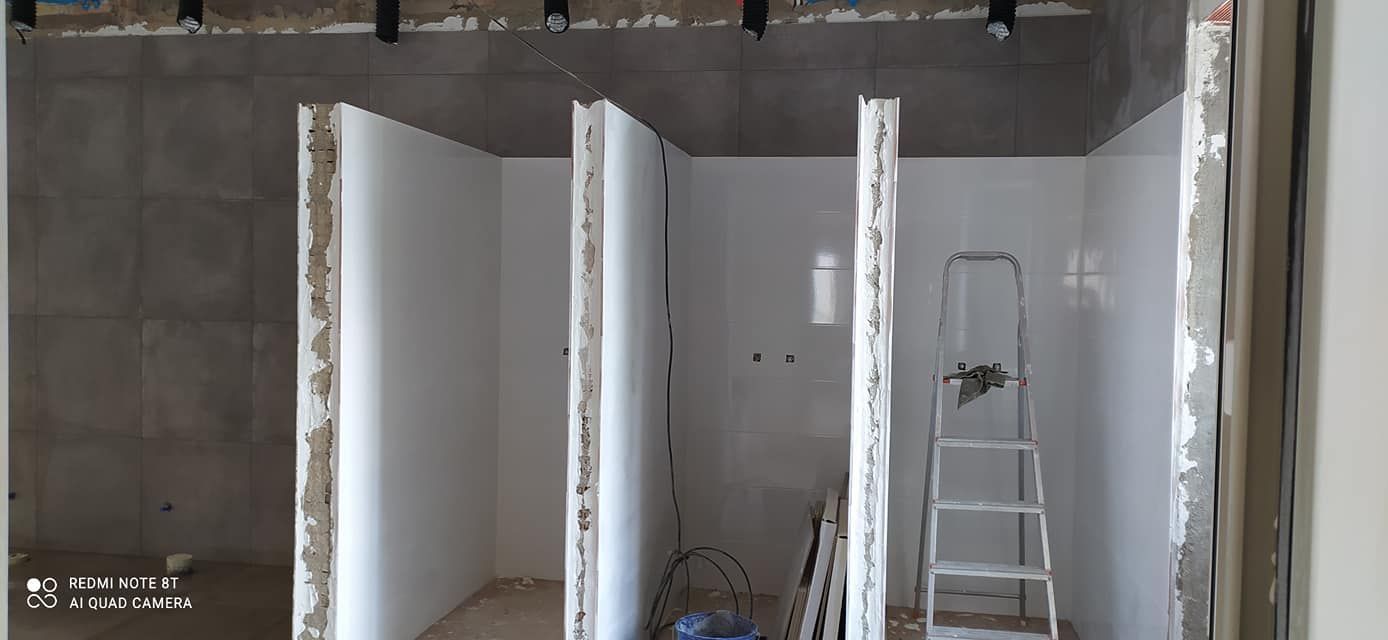 Una habitación con paredes blancas y una escalera en ella.