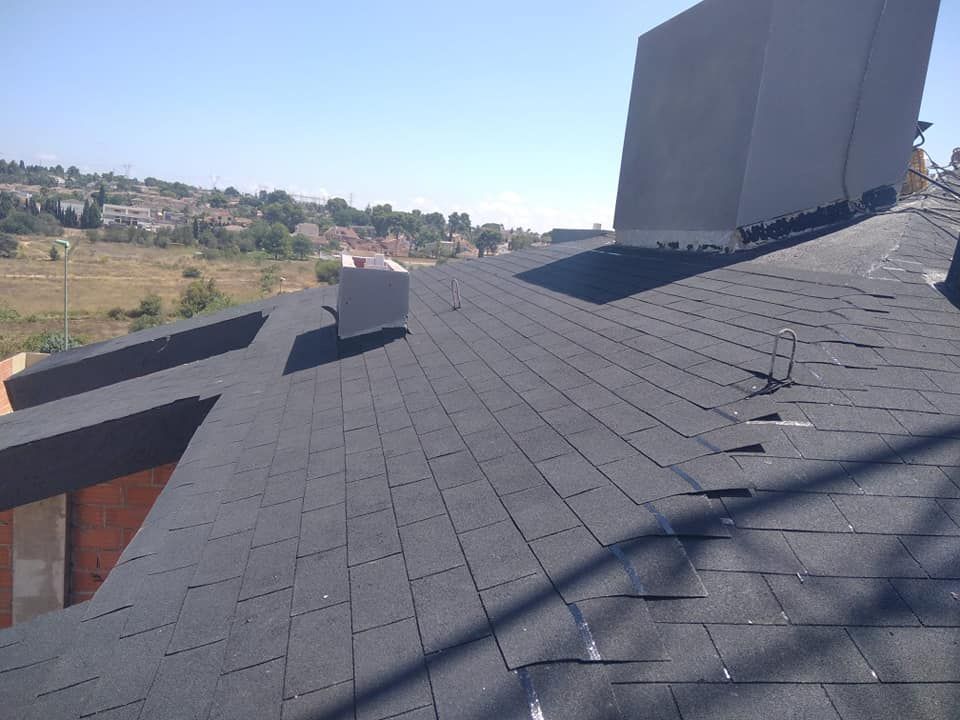 Un techo negro con una chimenea encima.