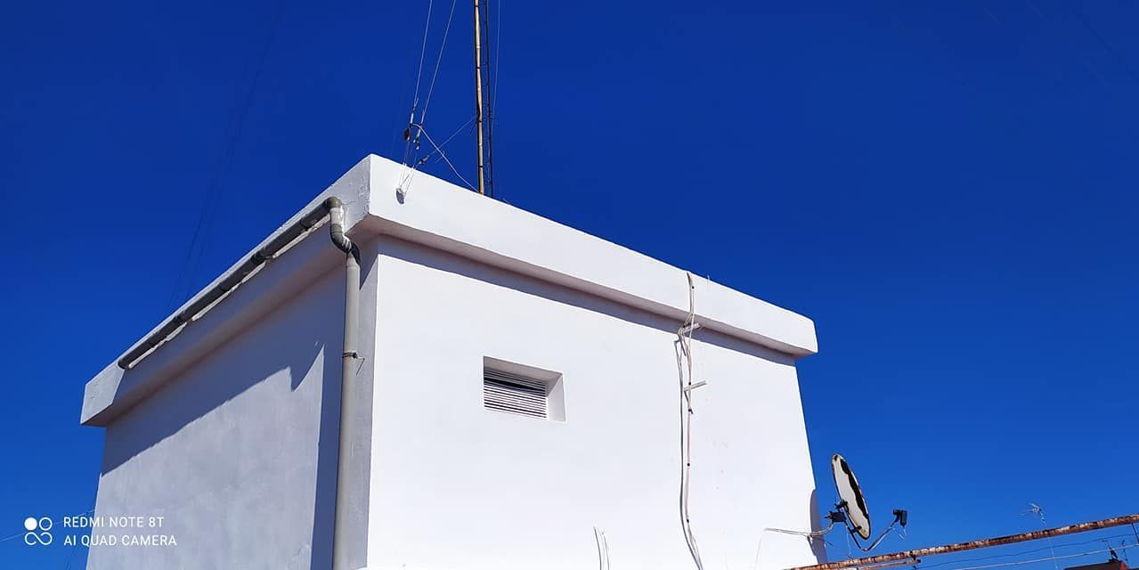 Un edificio blanco con un cielo azul al fondo.
