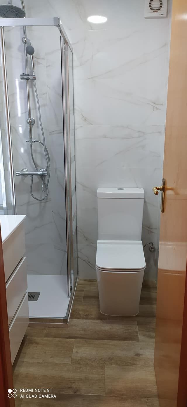 Un baño con inodoro, ducha y lavabo.