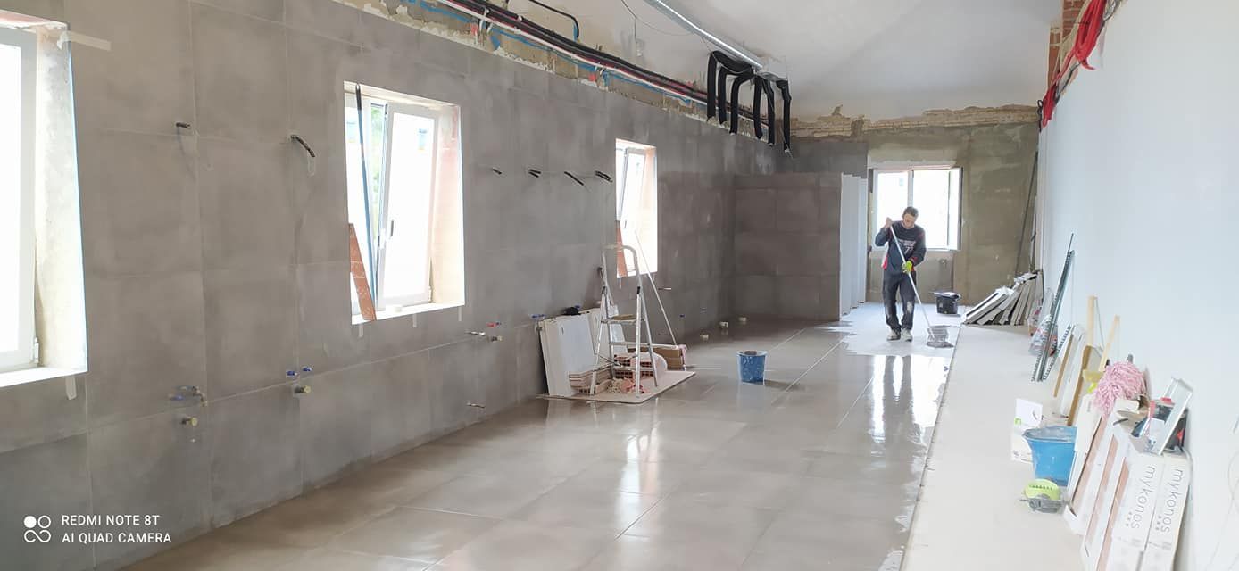 Un hombre está de pie en una habitación grande con muchas ventanas.