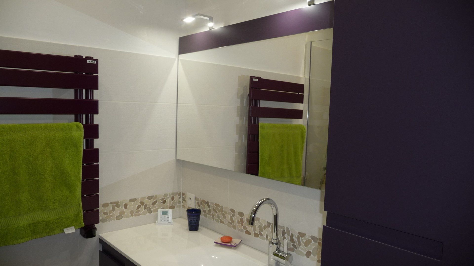 Carrelage dans une salle de bains et sa frise en galets