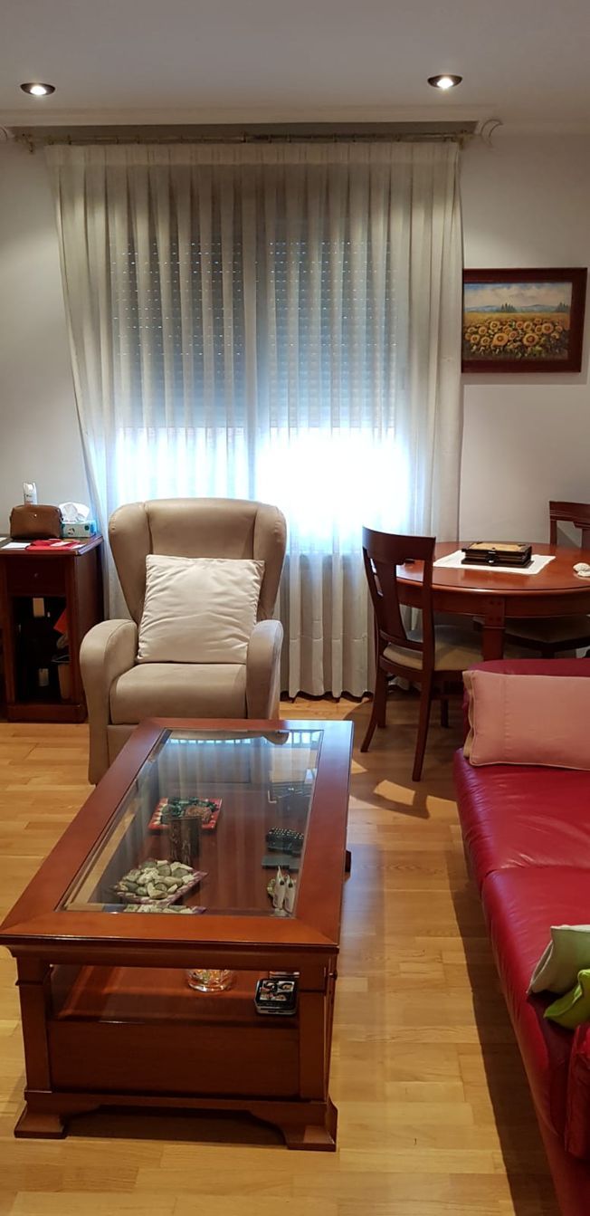 Una sala de estar con un sofá rojo y una lámpara.