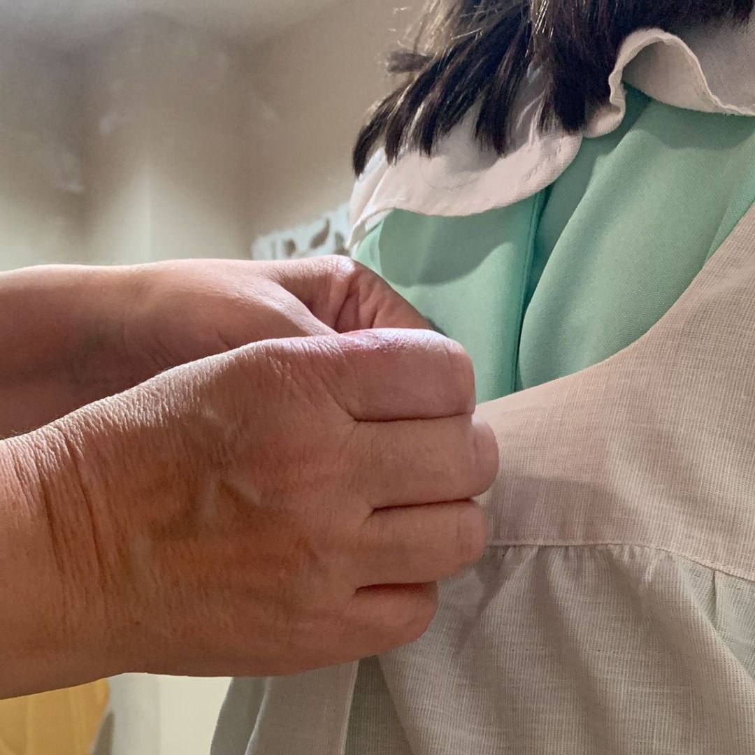 Un primer plano de una persona sosteniendo el brazo de un niño.
