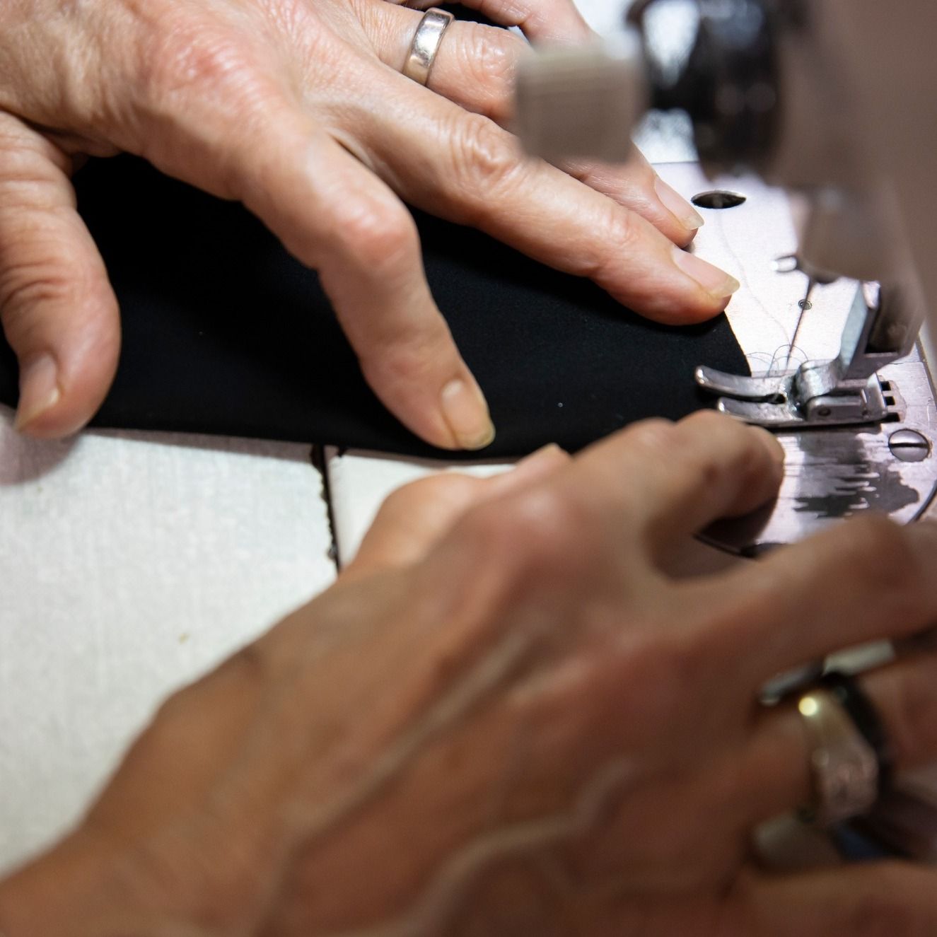 Un primer plano de las manos de una persona usando una máquina de coser.