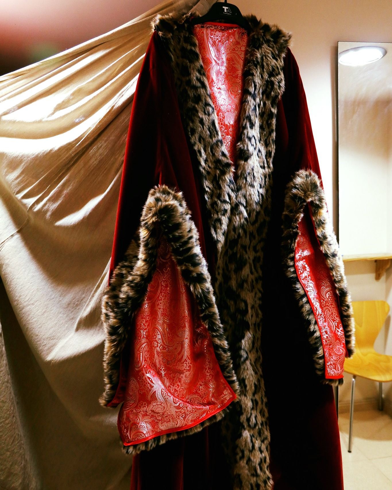 Un abrigo con estampado de leopardo está colgado en una percha.