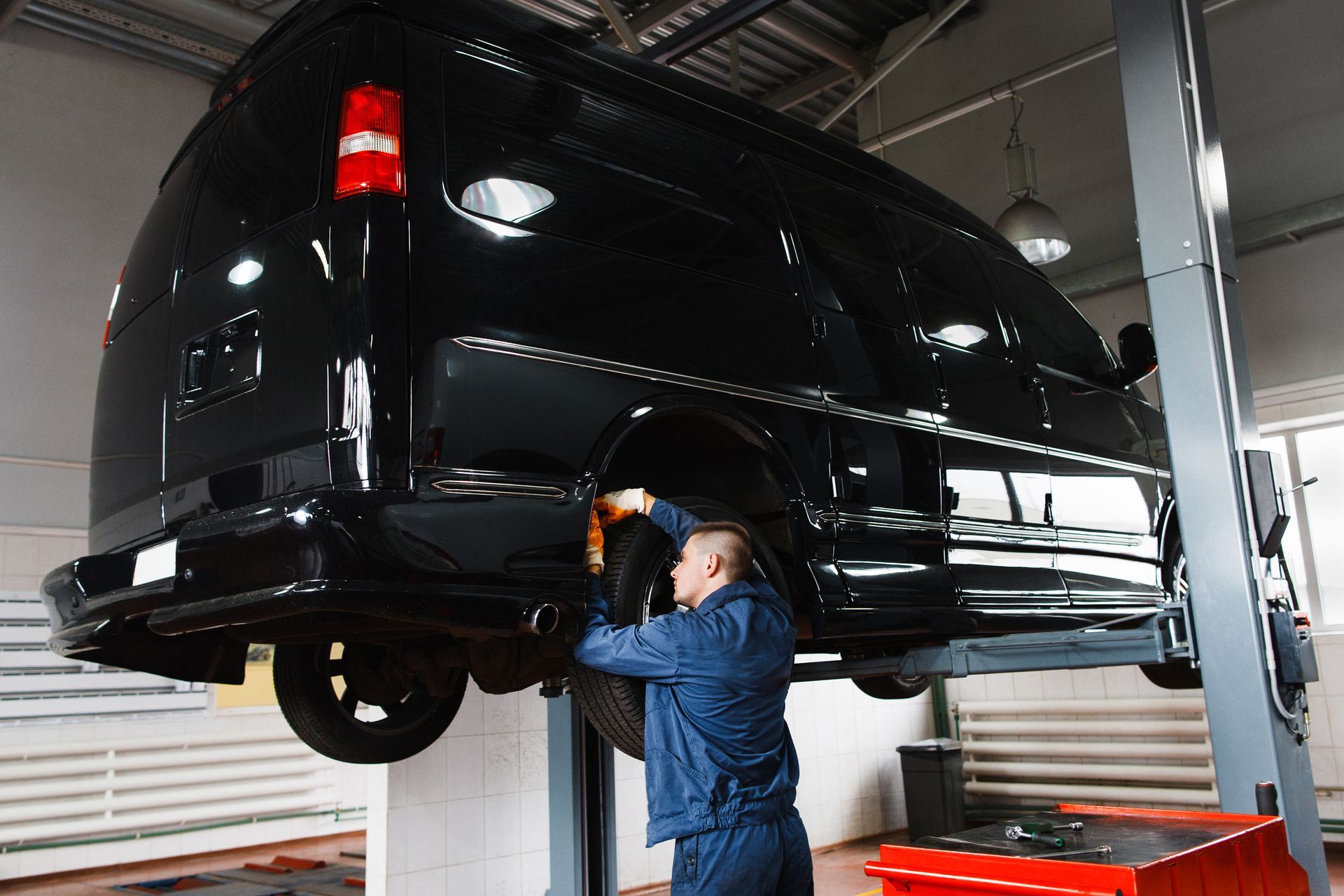 Garagiste travaillant sur un minibus noir