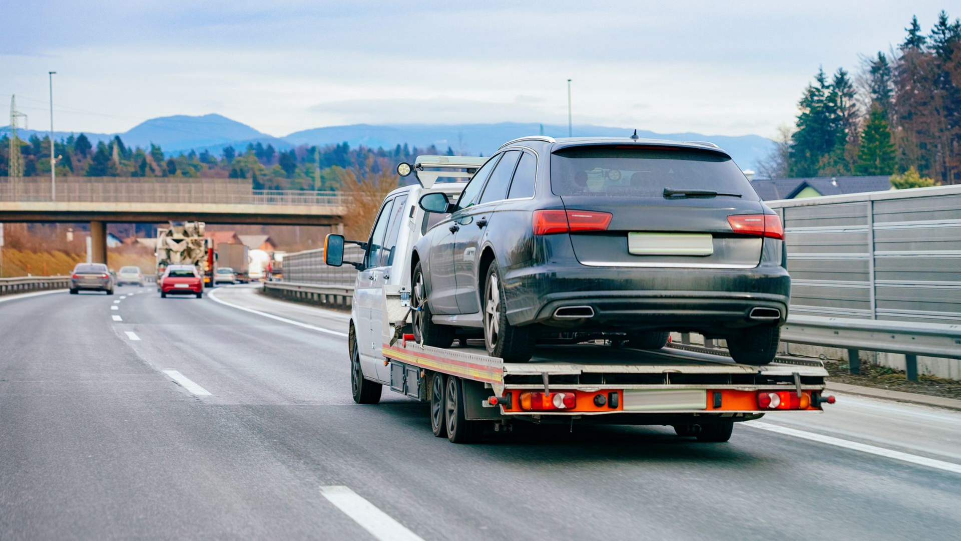 Voiture transportée par un camion sur une autoroute