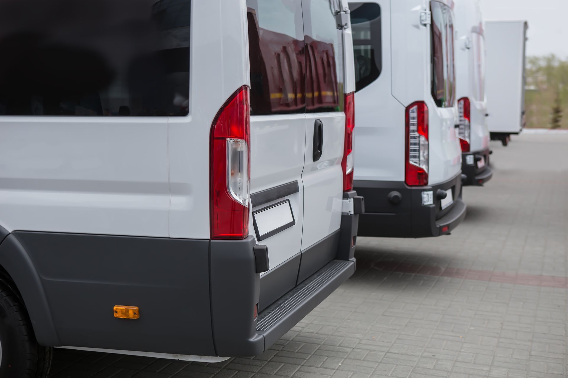Trois minibus blancs vus de derrière