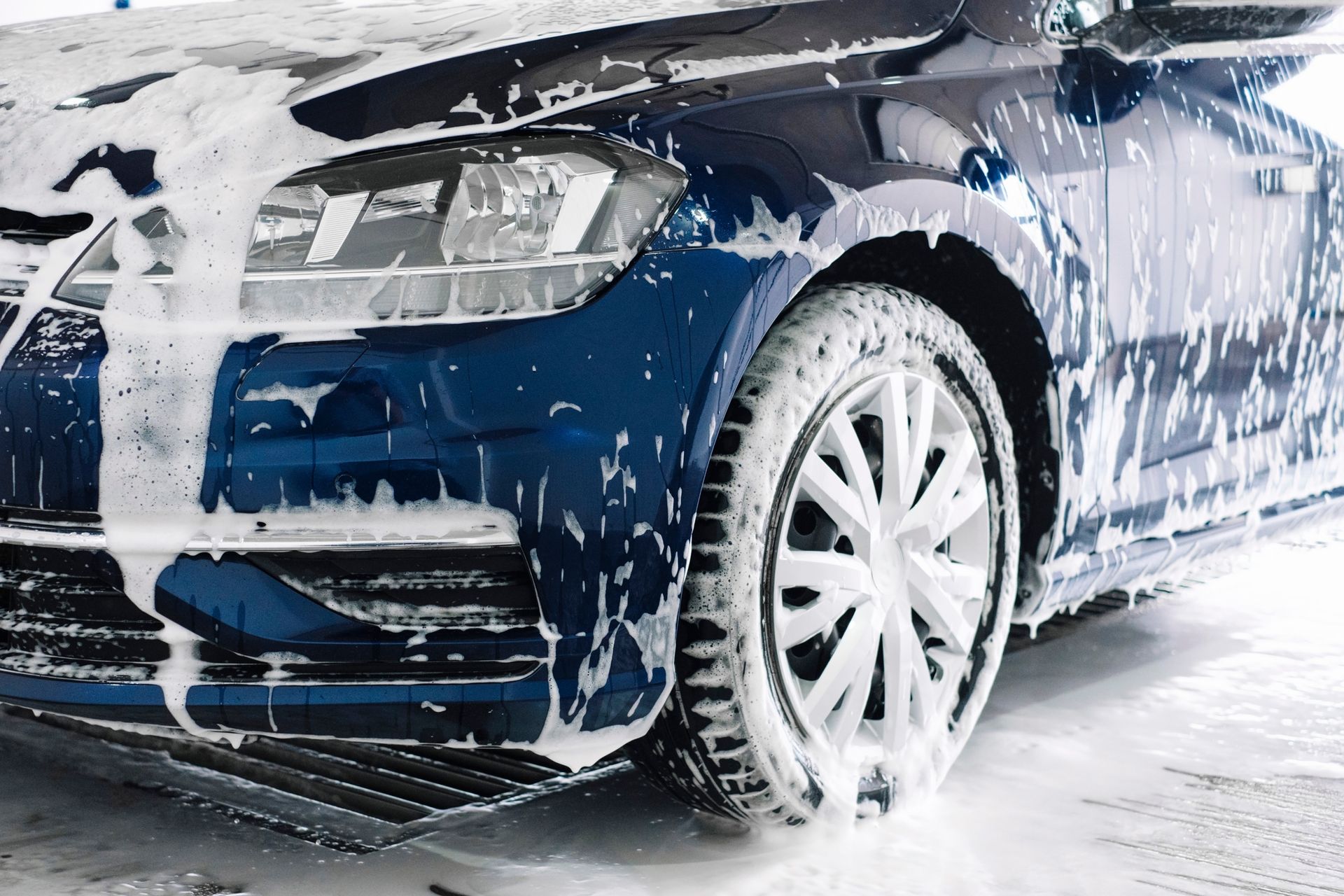 Voiture bleue recouverte d'un produit moussant