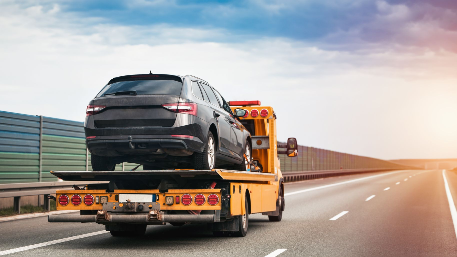 Une voiture break transportée par un camion