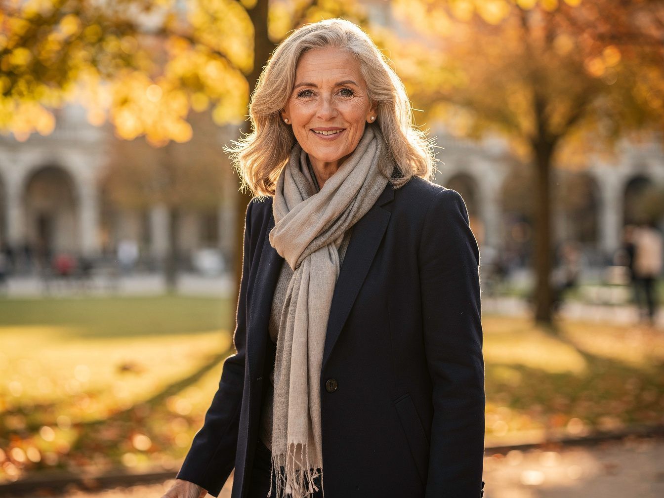 Lächelnde Frau in den Fünfzigern im herbstlichen Hofgarten
