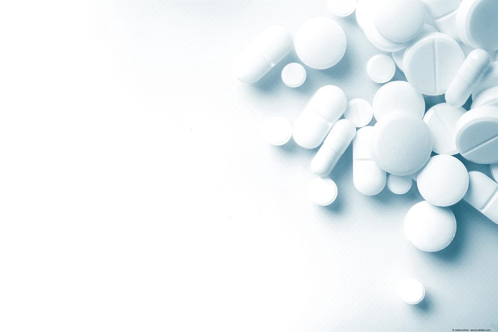 White tablets and capsules on a light background
