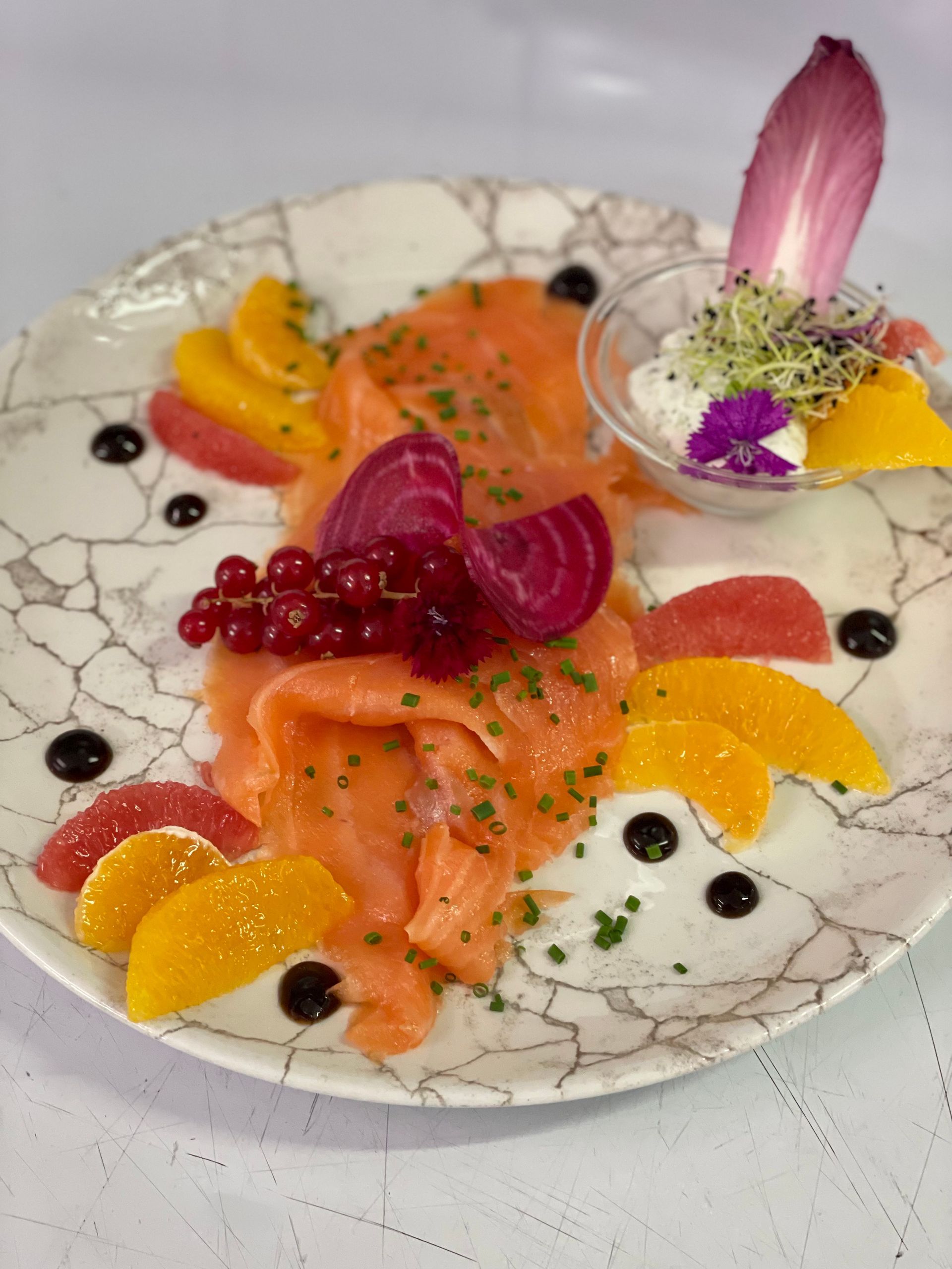 Plat de fruits, groseilles et légumes présenté dans une assiette blanche.