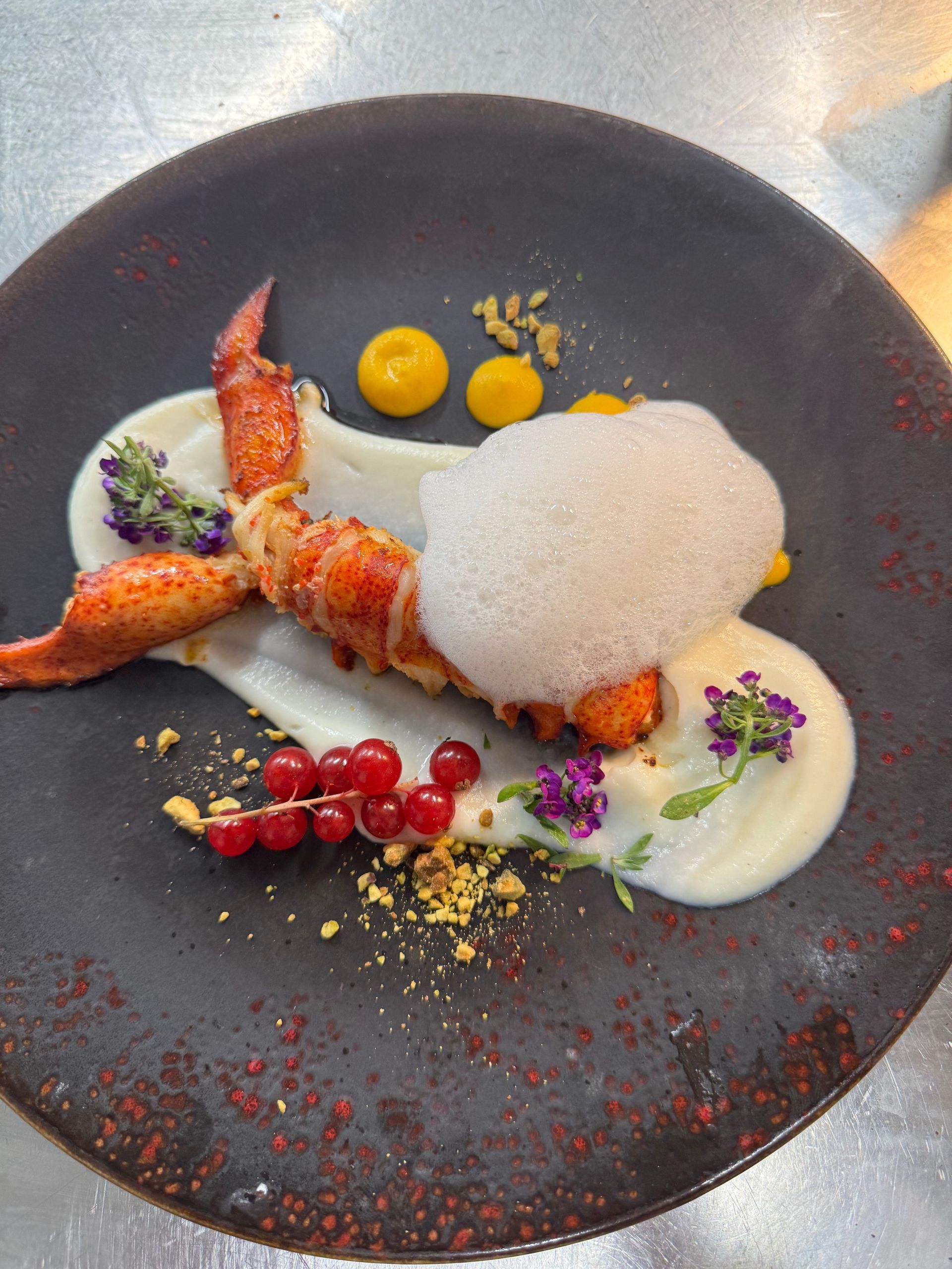 Plat de fruit de mer présenté dans une assiette noire.