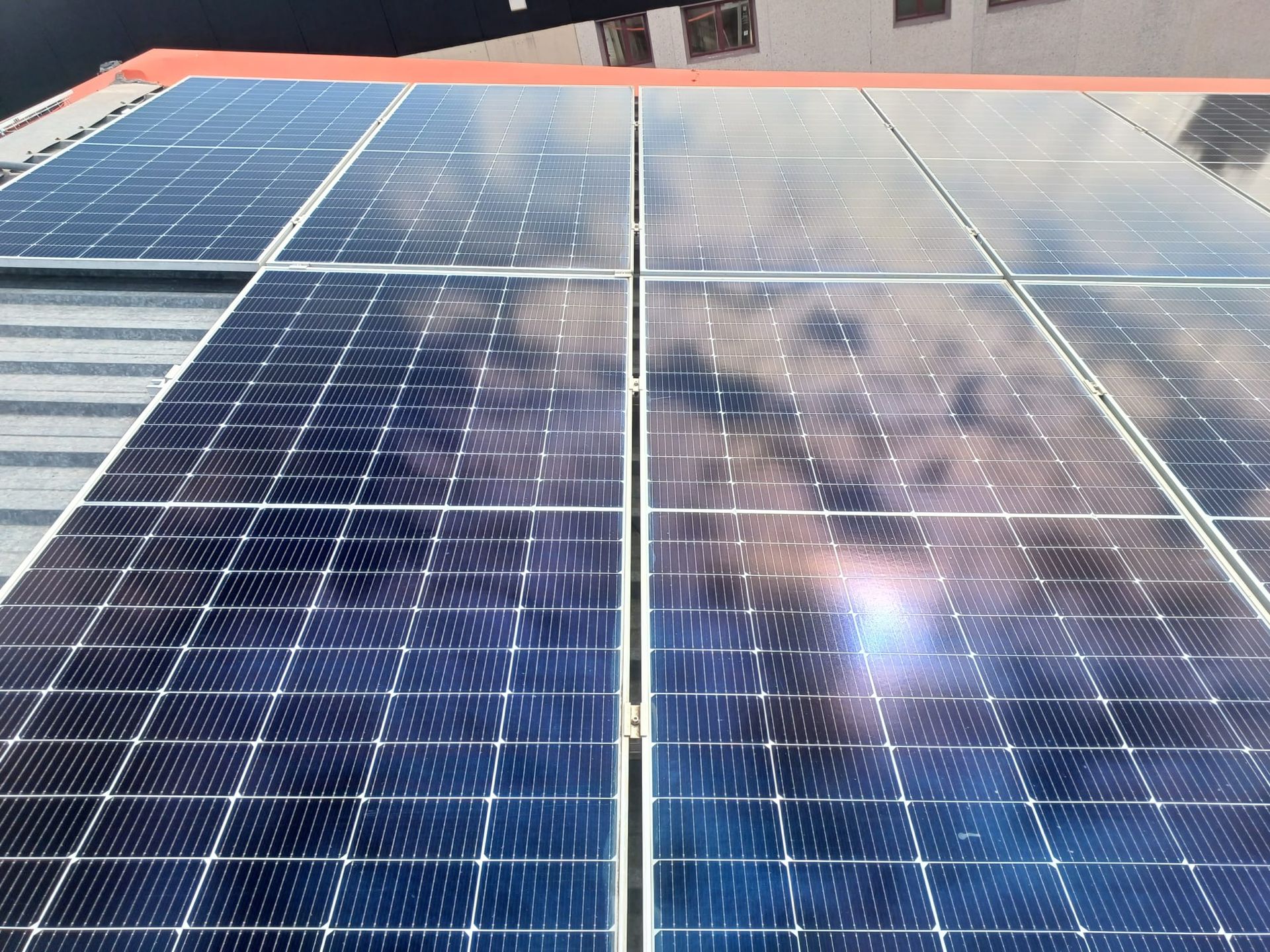 Paneles solares en un tejado, reflejando el cielo.