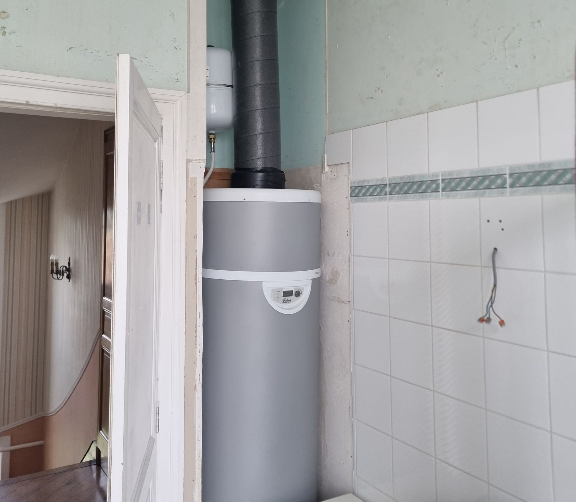 Chauffe-eau thermodynamique gris, pièce avec murs en carrelage