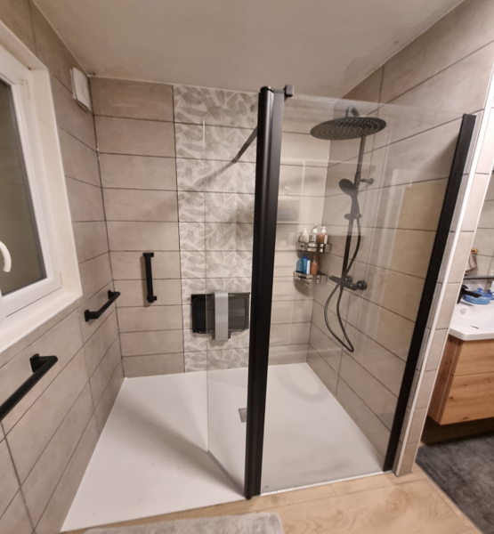 Douche à l'italienne, murs carrelés, meuble vasque et barres d'appui