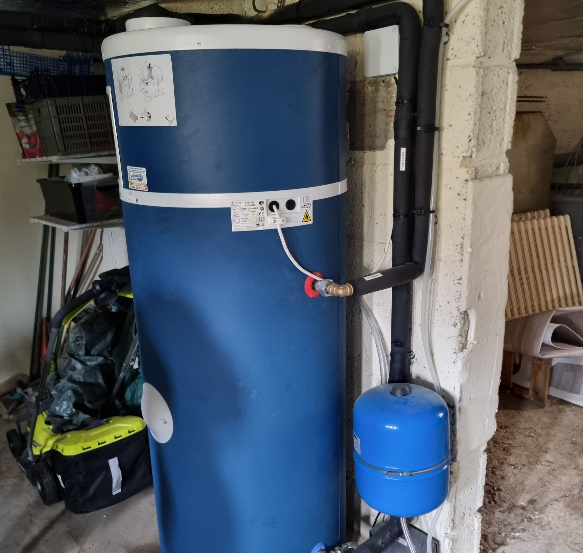 Chauffe-eau thermodynamique bleu, canalisations recouvertes avec des protections noires