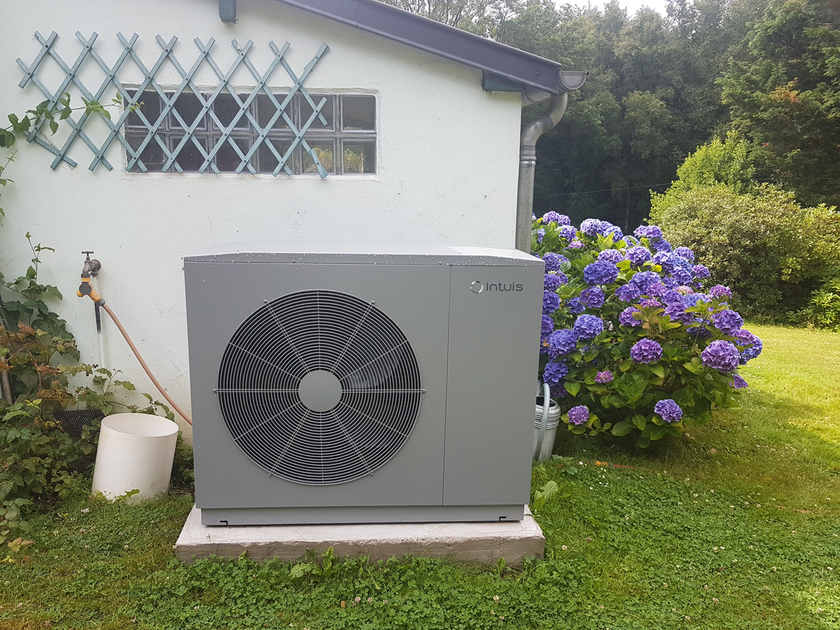 Pompe à chaleur devant un cabanon de jardin