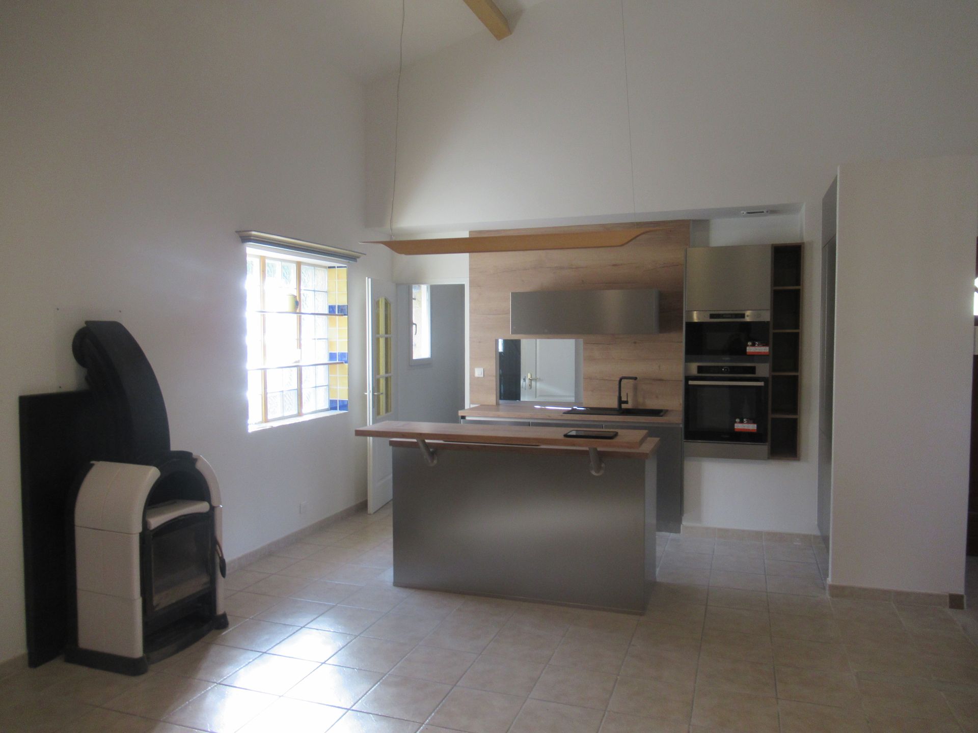 Cuisine moderne aux murs blancs avec un poêle