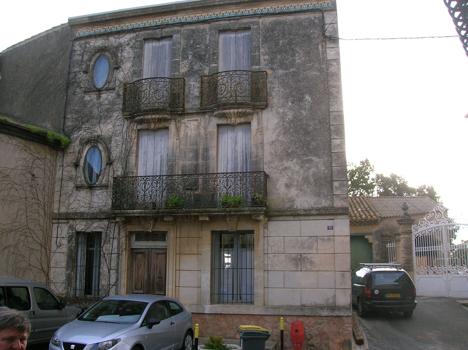 Façade sale avec des voitures garées à côté