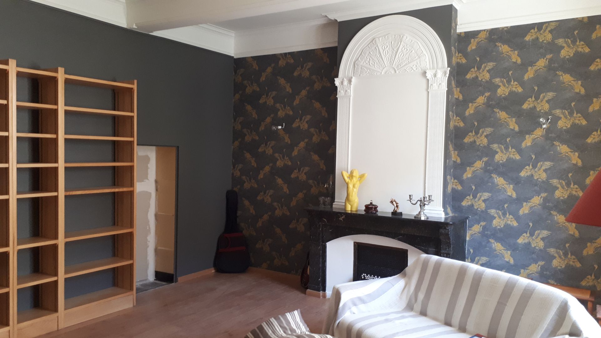 Murs sombres avec des imprimés et un dessus de cheminé blanc