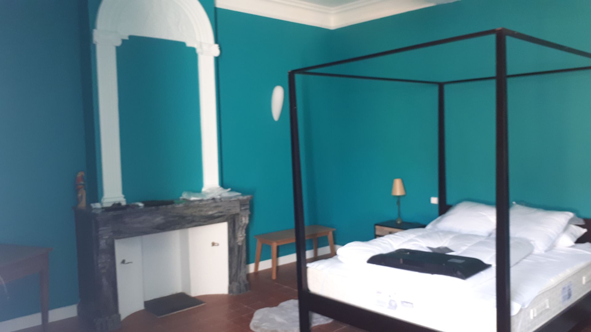 Chambre à coucher bleue avec cheminée et lit à baldaquin