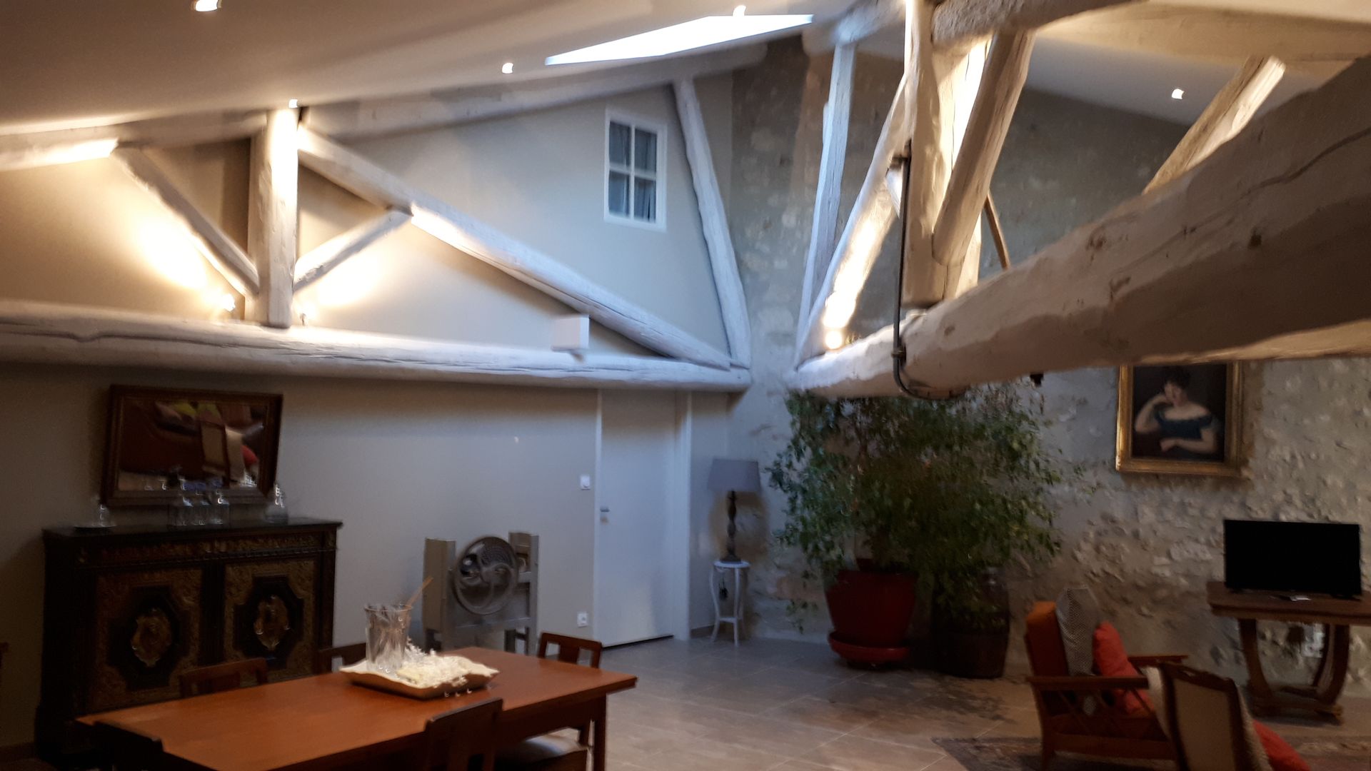 Pièce de vie avec de grosses poutres apparentes blanches