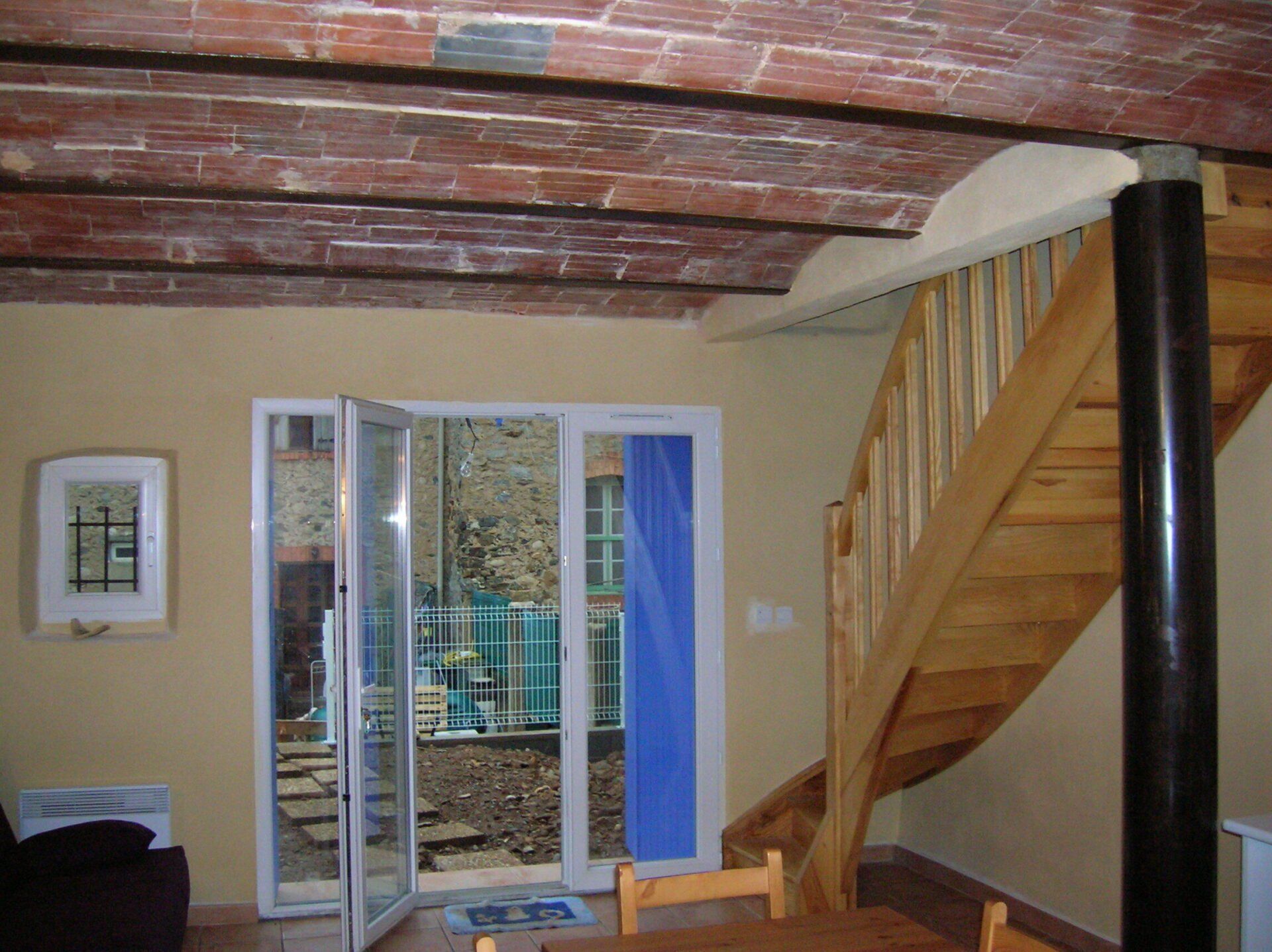Baie vitrée neuve avec escaliers en bois à côté