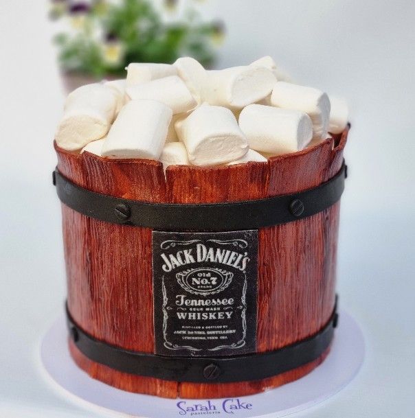 Un pastel con forma de barril de Jack Daniels lleno de malvaviscos.