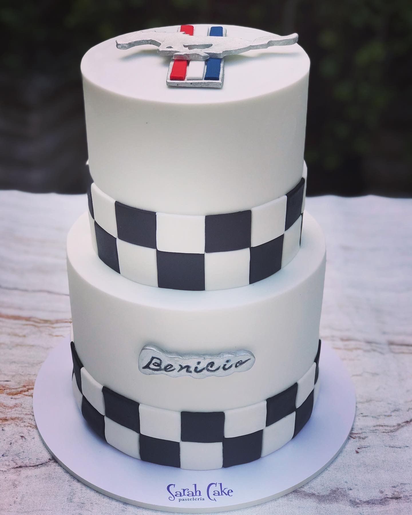 Un pastel a cuadros en blanco y negro con el nombre Benicio.