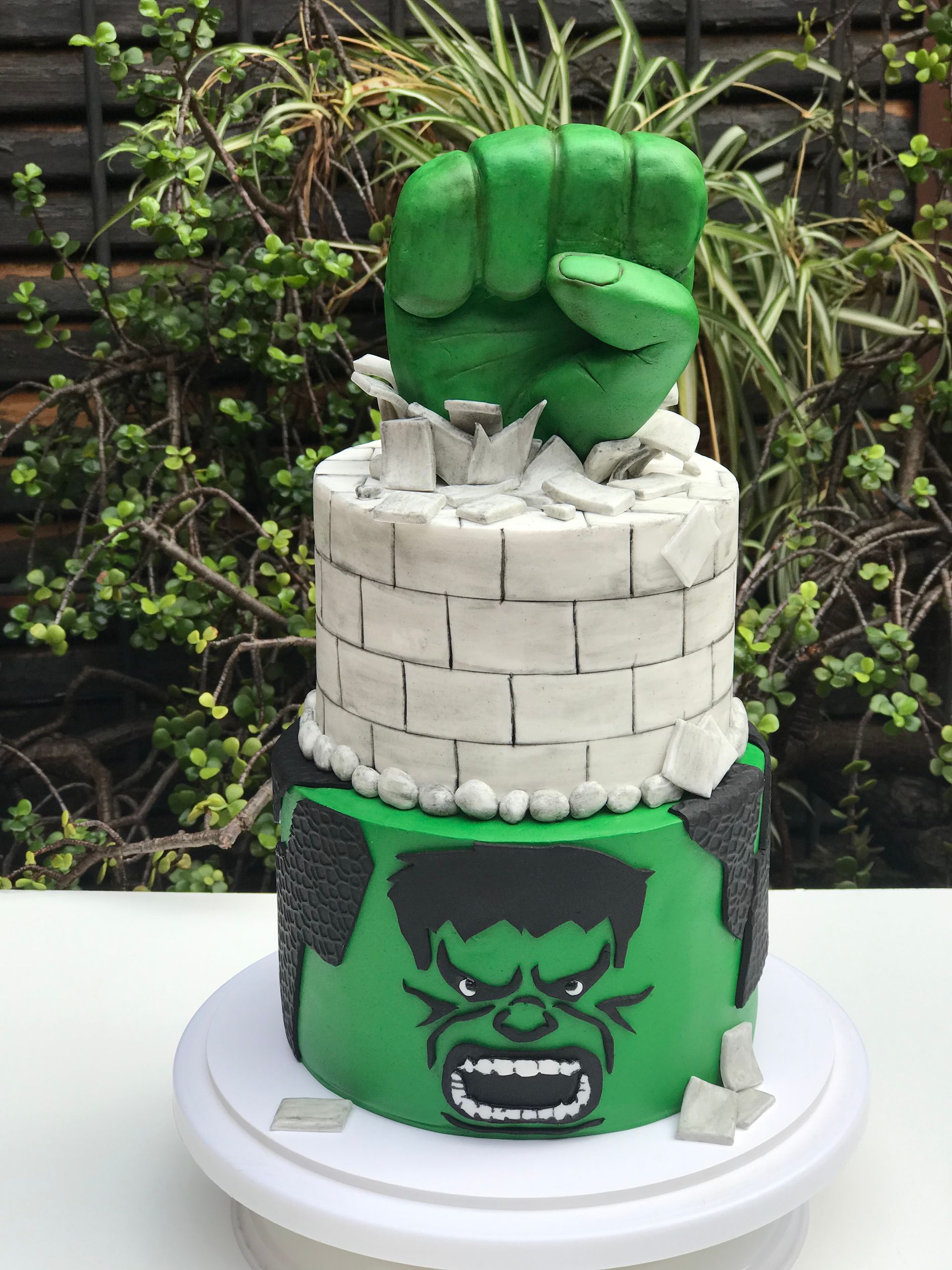 Un pastel de Hulk con una mano verde encima.