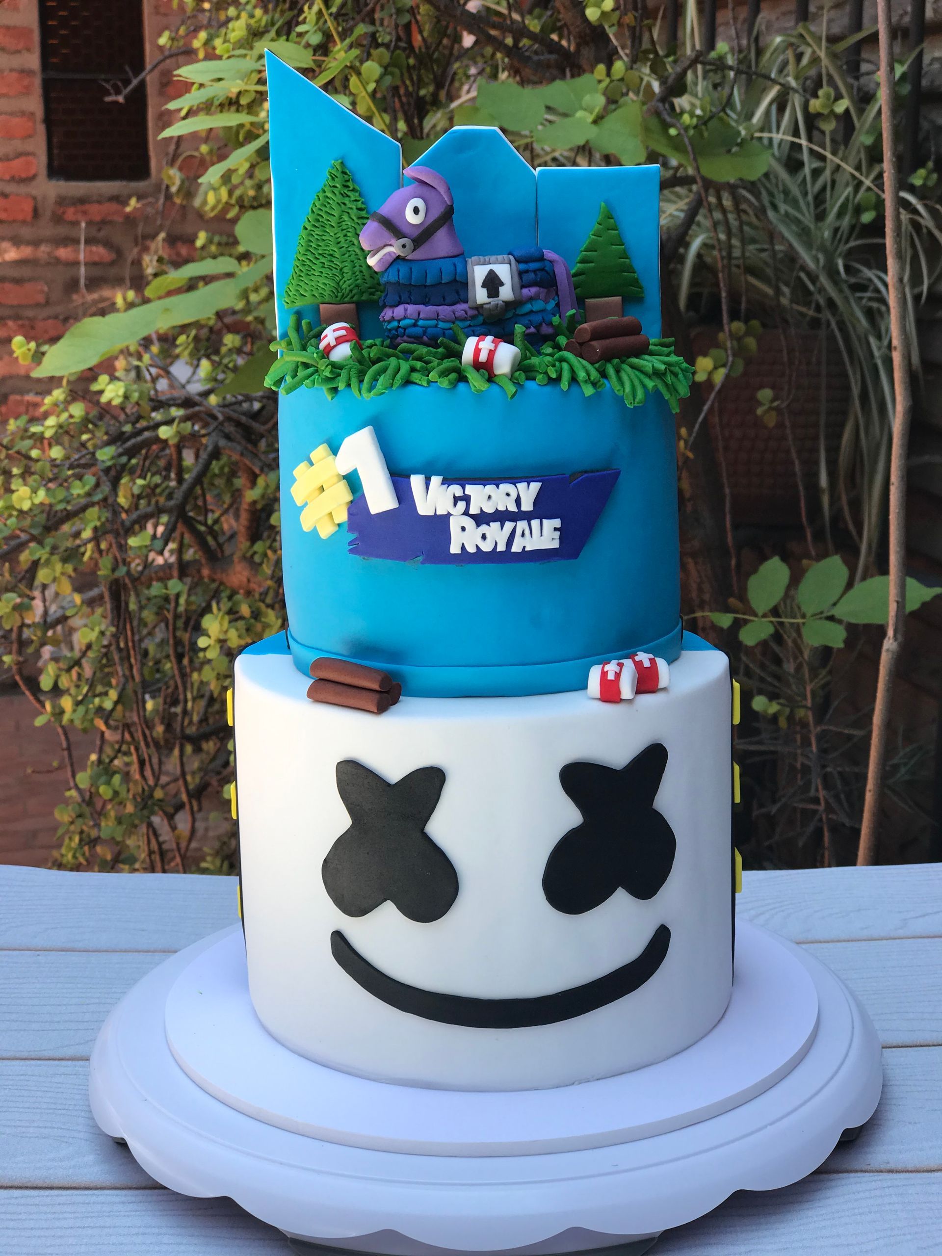 Un pastel azul y blanco con una cara de malvavisco.