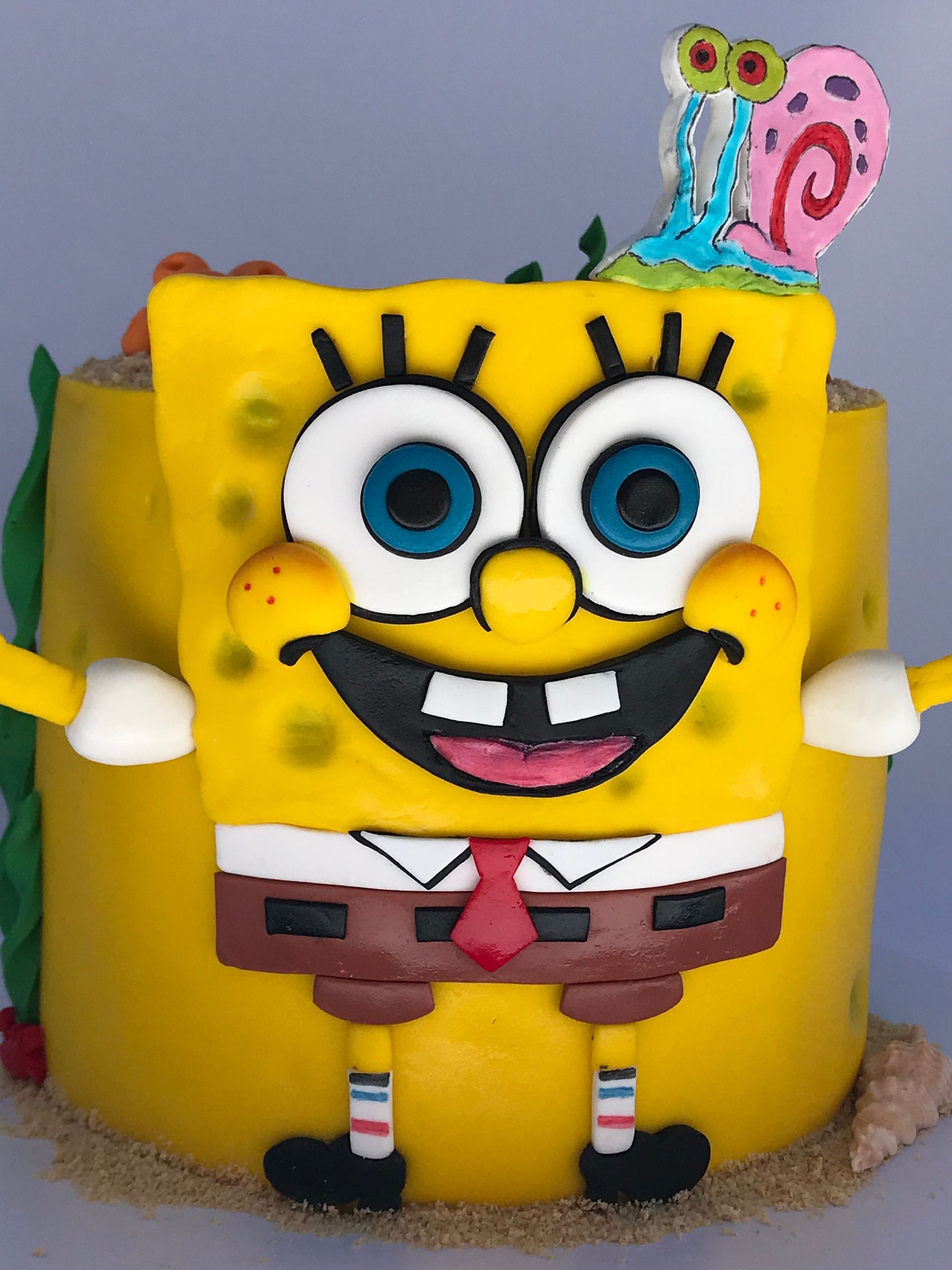 Un pastel de Bob Esponja con un caracol encima.