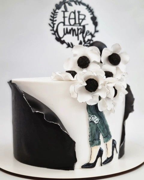 Un pastel en blanco y negro con un adorno de feliz cumpleaños.